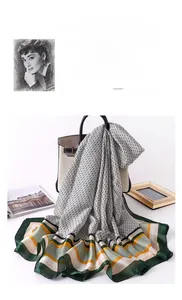 Detail of elegant geometric print scarf with stripes draped over a beige handbag