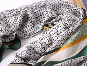 Detailed macro shot of printed silk scarf showing fine texture and geometric pattern