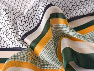 Detailed view of the luxury silk scarf showing intricate geometric patterns and textures