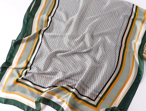 Macro shot of faux silk scarf showing geometric Y-pattern with multicolor striped border