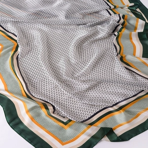 Close-up of silk texture scarf showing geometric pattern and multi-color border details