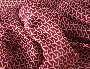 Detailed view of the smooth silk-like fabric with a classic Y-pattern and draped folds