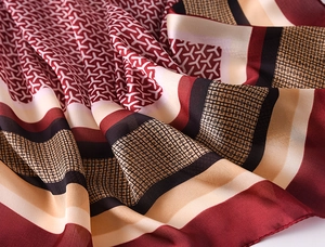 Detailed view of silk scarf texture with modern geometric patterns and rolled edge stitching