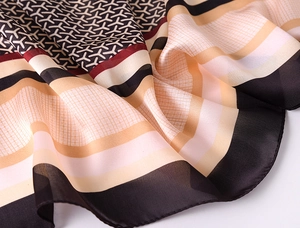 Detail shot of geometric pattern silk scarf with soft drape and satin luster finish