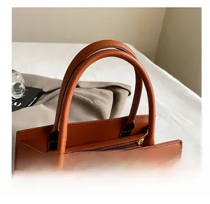 Detail shot of caramel leather bag with animal texture, double handles and gold twist lock