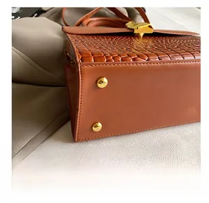 Close-up of crocodile pattern leather handbag with protective gold metal bottom studs