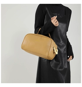 Close-up of khaki PU leather makeup bag with handle and white decorative zipper pull