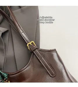 Detail of oil wax leather tote featuring adjustable shoulder strap with gold hardware