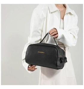 Détail du grain de cuir noir et double fermeture éclair dorée sur le sac à main