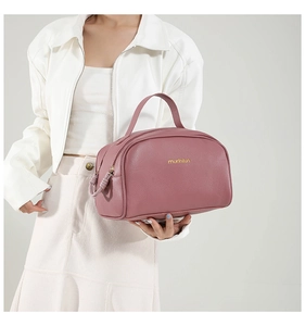Détail de la trousse de maquillage en cuir PU rose avec logo mudilun doré et fermeture éclair