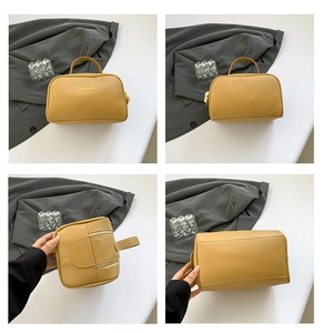 Detail view of mustard yellow pebbled leather handbag with metal zipper and handle