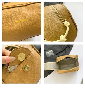 Detail view of lychee pattern leather handbag with magnetic snap and metal zipper closure