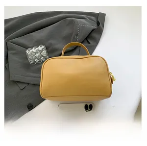 Detail view of the yellow PU leather toiletry bag with textured finish and sturdy handle