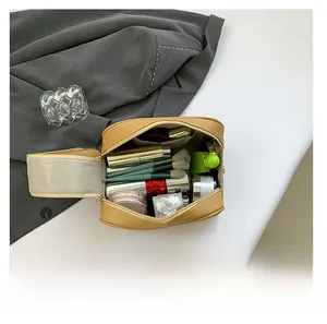 Detail view of khaki PU leather toiletry bag showing spacious interior with makeup brushes