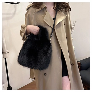 Fashionable black faux fur handbag with gold hardware styled with a trench coat