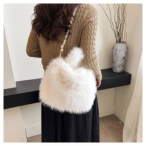 Detail of white faux fur handbag with adjustable strap and golden metal buckle