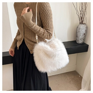 Detailed view of fluffy faux fur shoulder bag worn by model featuring gold hardware