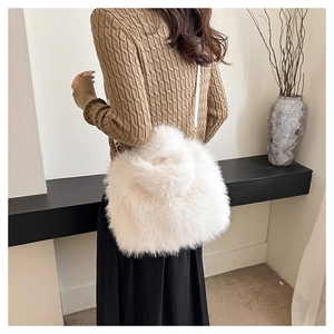 Detail of plush faux fox fur handbag showing white texture and metal strap hooks