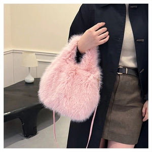 Detail view of pink faux fox fur handbag showing soft plush texture and long shoulder strap