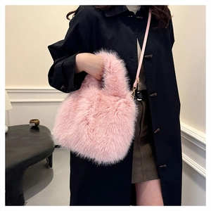 Detail of pink faux fur bucket bag with plush texture and detachable shoulder strap