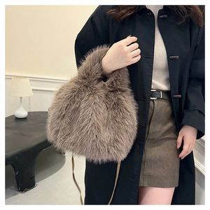 Close-up of a fluffy faux fur bucket bag in taupe with slender matching shoulder strap