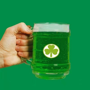 Glass beer mug with white shamrock pattern and green liquid for St. Patrick's Day gift