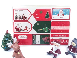 Close-up of Merry Christmas gift tags featuring Santa, reindeer, and snowflakes patterns