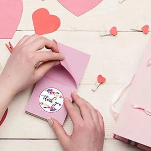 Colorful feather Thank You stickers on white wood for gift packaging and envelope sealing