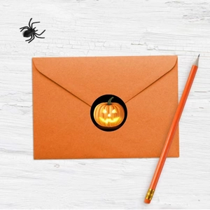 Halloween pumpkin stickers for envelope sealing on white wooden background with decorations
