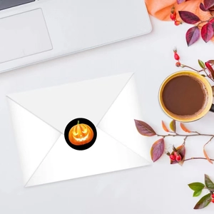 Halloween pumpkin sticker sealing a white envelope with autumn leaves and coffee decor