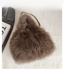 Detail of a brown faux fox fur shoulder bag with triangle shape and slim leather strap