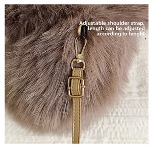 Detail of faux fox fur bag with adjustable leather strap and gold metal hardware