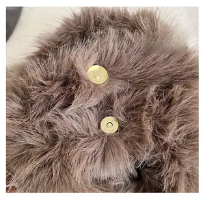 Close-up of premium golden magnetic clasp on brown faux fox fur handbag detail