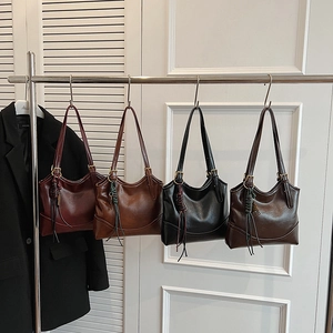 Chic oil wax leather tote bags in four colors hanging on a rack for daily commute