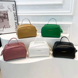 Five colored PU leather toiletry bags with gold zippers on a minimalist display