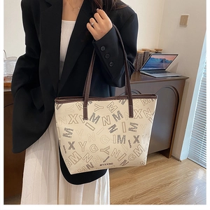 Minimalist beige tote bag with black letter print and dark brown leather shoulder straps