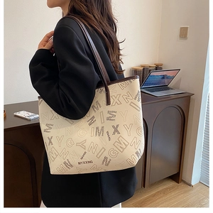 Close-up of minimalist tote bag with letter patterns and leather handles for commute