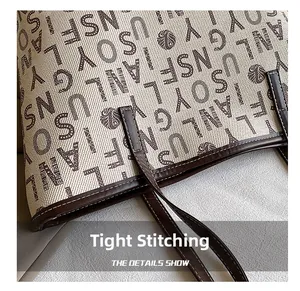 Close-up of tight stitching on dark brown leather handle and beige printed tote bag