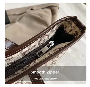 Close-up of smooth silver metal zipper and brown leather trim on retro tote bag