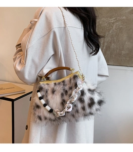 Détail du sac à main en fausse fourrure avec poignée en bois et bandoulière en perles