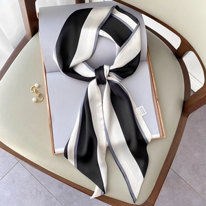Eleganter schwarz-weiß gestreifter Seidenschal mit Schleife und Perlenohrringen