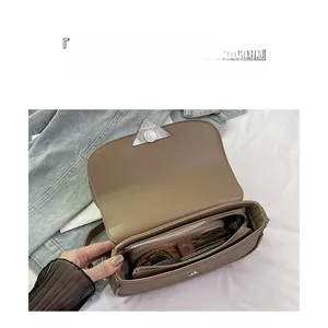 Vue détaillée de l'intérieur du sac à bandoulière kaki avec compartiments et poche zippée