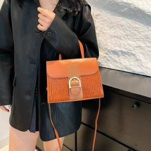 Modische orangefarbene Handtasche mit Krokodilprägung und goldener Schnalle im Streetstyle