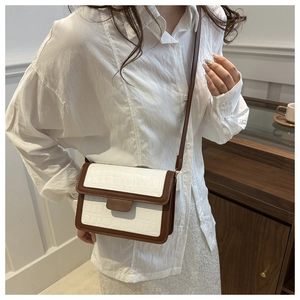 Model wearing a vintage crossbody bag with crocodile texture and brown leather trim