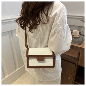 Detail of color-block stone texture crossbody bag worn by a model in casual setting