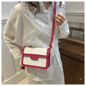 Detail of white crocodile texture leather crossbody bag with magenta contrast edges