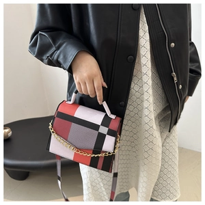 Detailed view of a retro plaid crossbody bag with gold chain and top handle on model