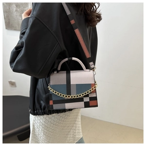 Detail of geometric color-block shoulder bag with gold chain and mixed strap