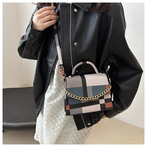 Detail view of the geometric color block pattern and chain strap on the small square bag