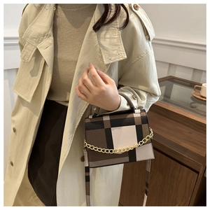 Detail of color-block crossbody bag styled with a khaki trench coat for a chic autumn look